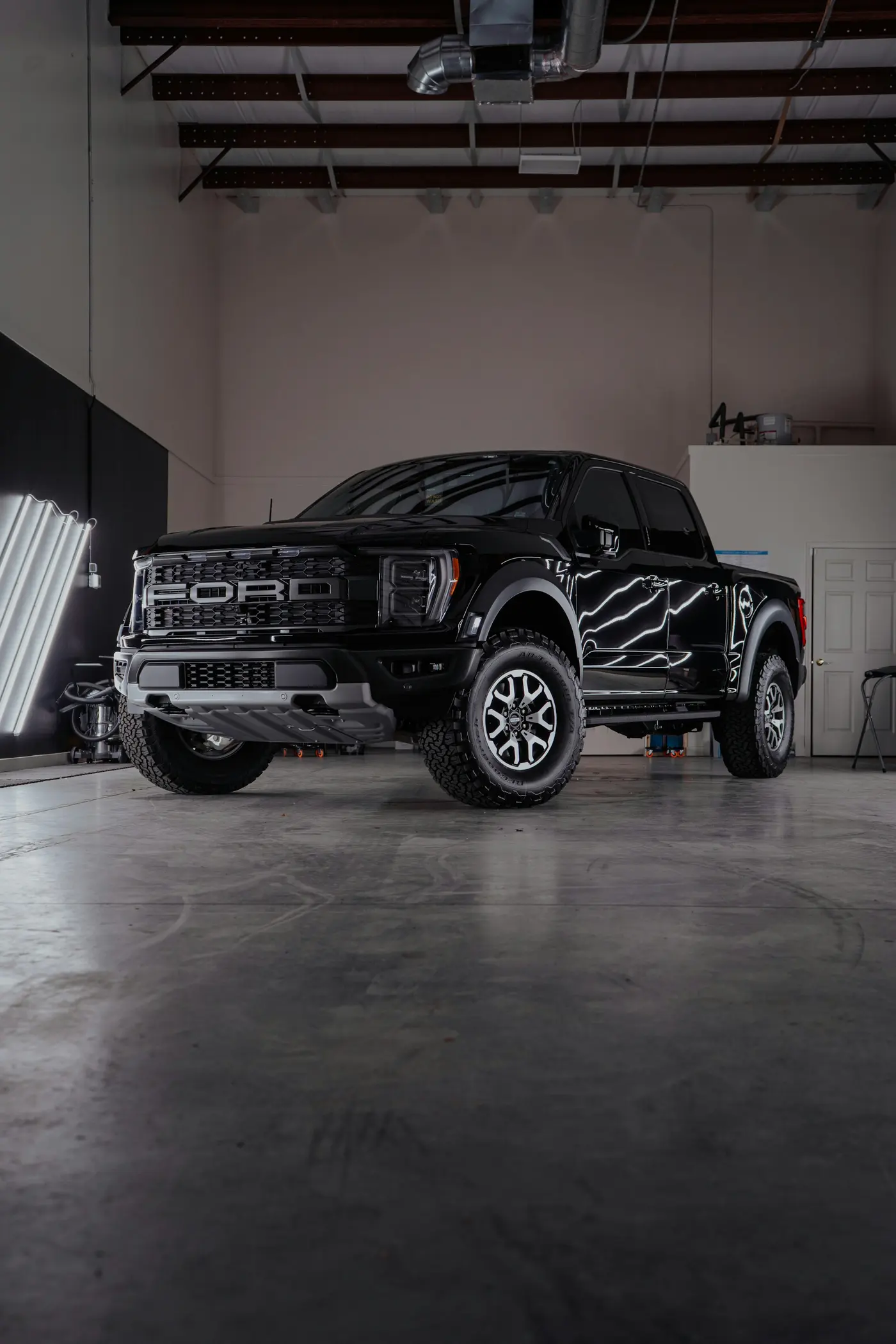 Black pickup truck parked in a clean, well-lit shop